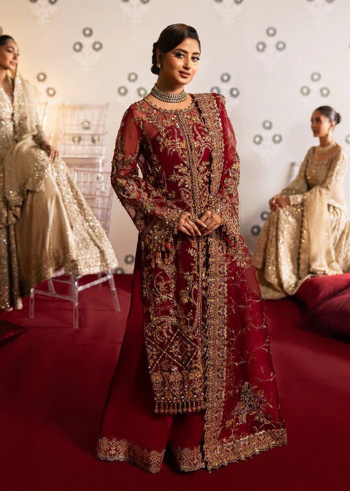 Model wearing Kanwal Malik Maahi Wedding Festive '24 ARMALA, a deep red ensemble with intricate gold embroidery, ideal for wedding celebrations. Available for Pakistani clothes online in the UK.