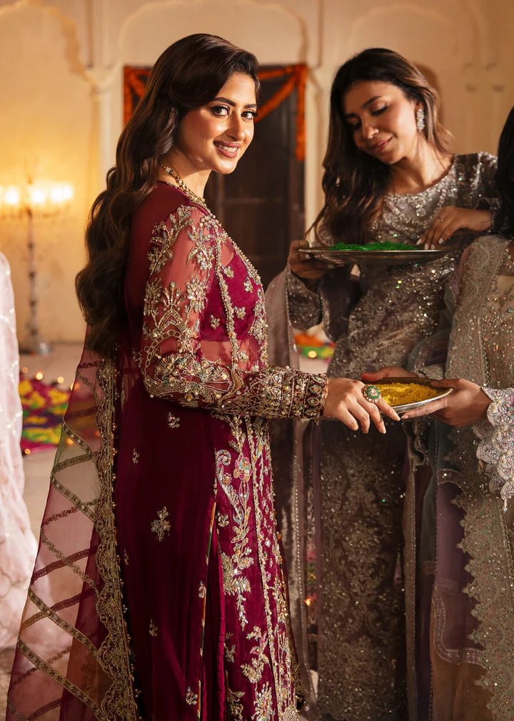 Model wearing Kanwal Malik Maahi Wedding Festive '24 ARMALA, a deep red ensemble with intricate gold embroidery, ideal for wedding celebrations. Available for Pakistani clothes online in the UK.