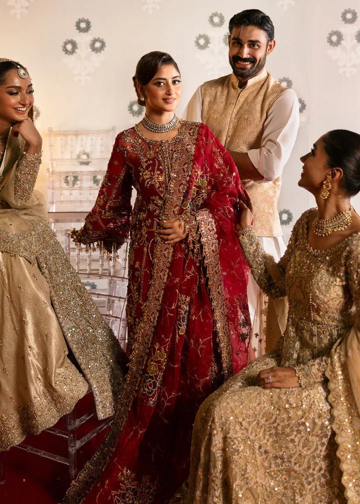 Model wearing Kanwal Malik Maahi Wedding Festive '24 ARMALA, a deep red ensemble with intricate gold embroidery, ideal for wedding celebrations. Available for Pakistani clothes online in the UK.