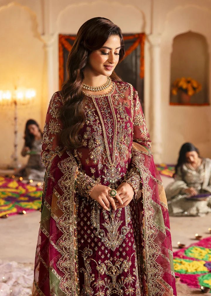 Model wearing Kanwal Malik Maahi Wedding Festive '24 FALAK, a deep maroon ensemble with intricate gold embellishments, perfect for weddings. Available for Pakistani clothes online in the UK.