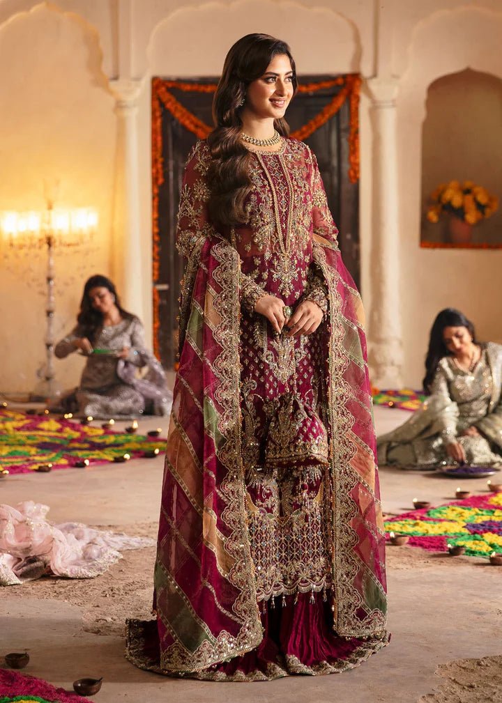 Model wearing Kanwal Malik Maahi Wedding Festive '24 FALAK, a deep maroon ensemble with intricate gold embellishments, perfect for weddings. Available for Pakistani clothes online in the UK.