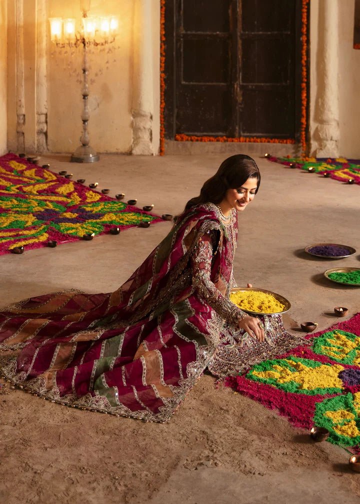 Model wearing Kanwal Malik Maahi Wedding Festive '24 FALAK, a deep maroon ensemble with intricate gold embellishments, perfect for weddings. Available for Pakistani clothes online in the UK.