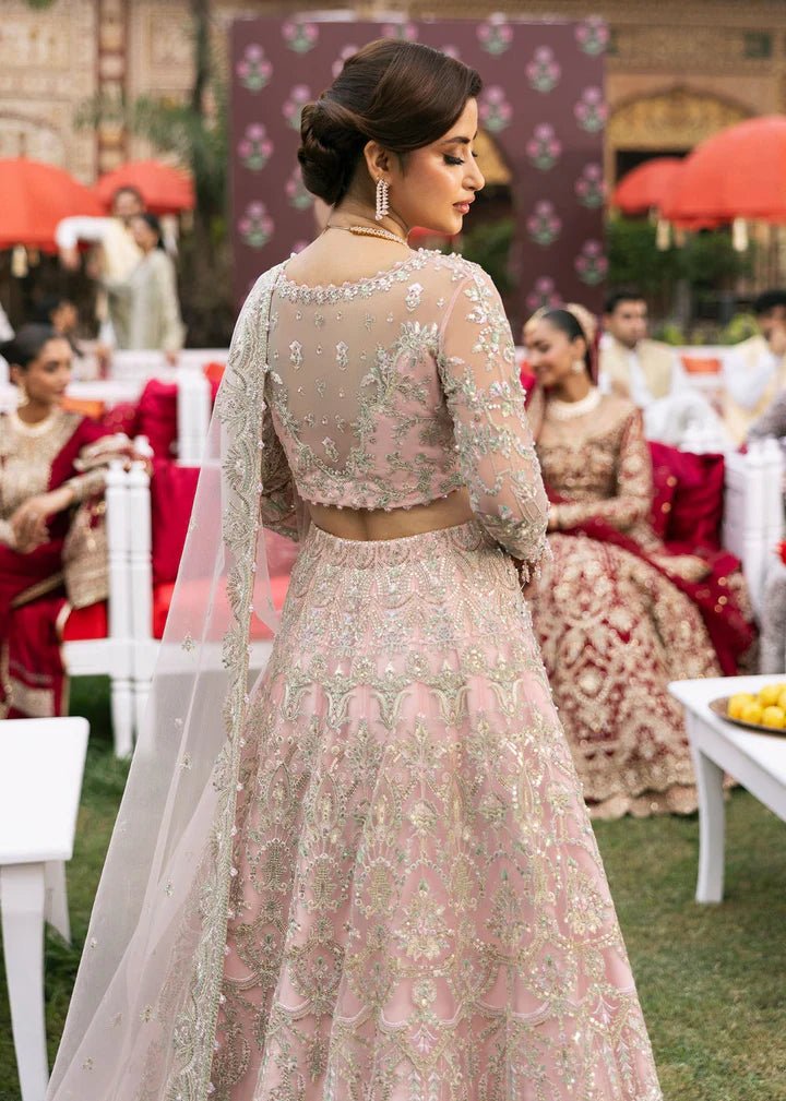 Model wearing Kanwal Malik Maahi Wedding Festive '24 NAGEEN, a soft pink bridal dress with intricate silver embellishments, ideal for weddings. Available for Pakistani clothes online in the UK.