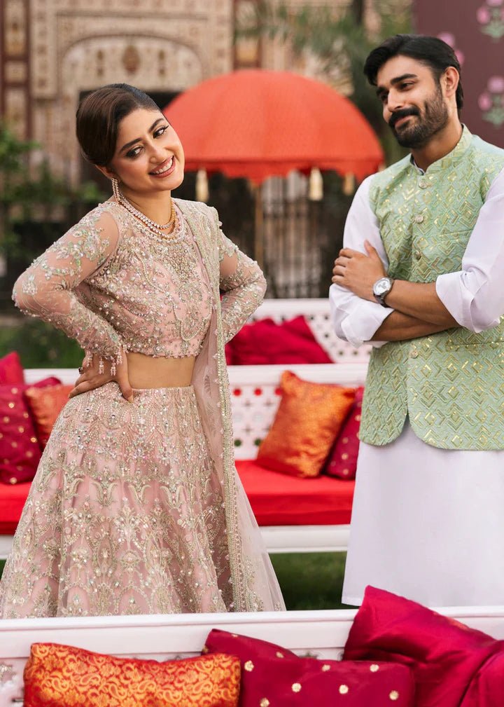 Model wearing Kanwal Malik Maahi Wedding Festive '24 NAGEEN, a soft pink bridal dress with intricate silver embellishments, ideal for weddings. Available for Pakistani clothes online in the UK.