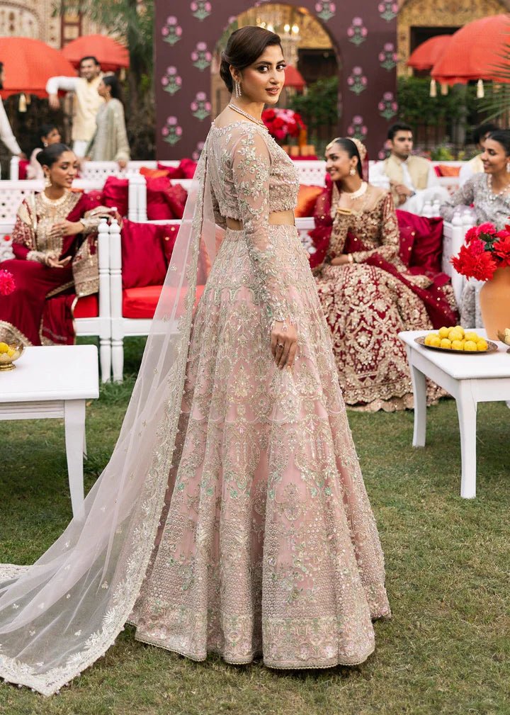 Model wearing Kanwal Malik Maahi Wedding Festive '24 NAGEEN, a soft pink bridal dress with intricate silver embellishments, ideal for weddings. Available for Pakistani clothes online in the UK.