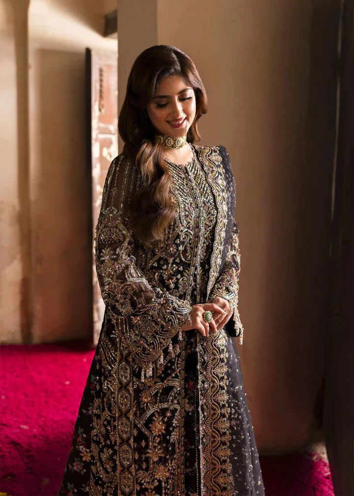 Model wearing Kanwal Malik Maahi Wedding Festive '24 ZAIB, a luxurious black ensemble adorned with intricate gold and silver embellishments, perfect for weddings. Available for Pakistani clothes online in the UK.