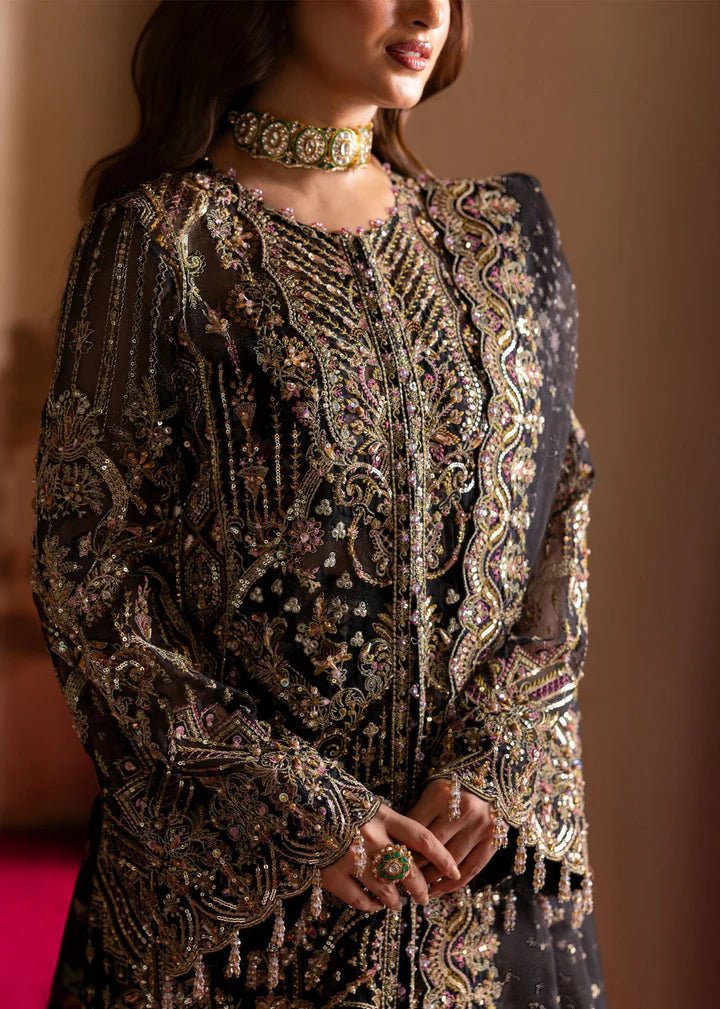 Model wearing Kanwal Malik Maahi Wedding Festive '24 ZAIB, a luxurious black ensemble adorned with intricate gold and silver embellishments, perfect for weddings. Available for Pakistani clothes online in the UK.