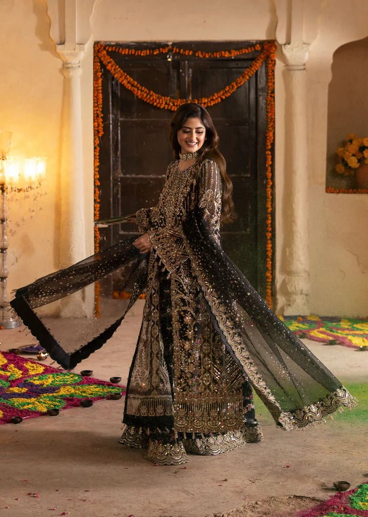 Model wearing Kanwal Malik Maahi Wedding Festive '24 ZAIB, a luxurious black ensemble adorned with intricate gold and silver embellishments, perfect for weddings. Available for Pakistani clothes online in the UK.