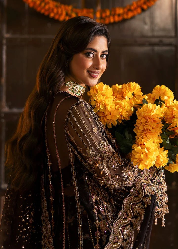 Model wearing Kanwal Malik Maahi Wedding Festive '24 ZAIB, a luxurious black ensemble adorned with intricate gold and silver embellishments, perfect for weddings. Available for Pakistani clothes online in the UK.