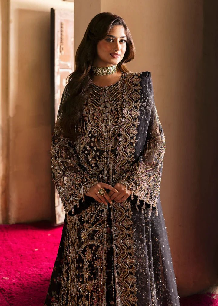 Model wearing Kanwal Malik Maahi Wedding Festive '24 ZAIB, a luxurious black ensemble adorned with intricate gold and silver embellishments, perfect for weddings. Available for Pakistani clothes online in the UK.