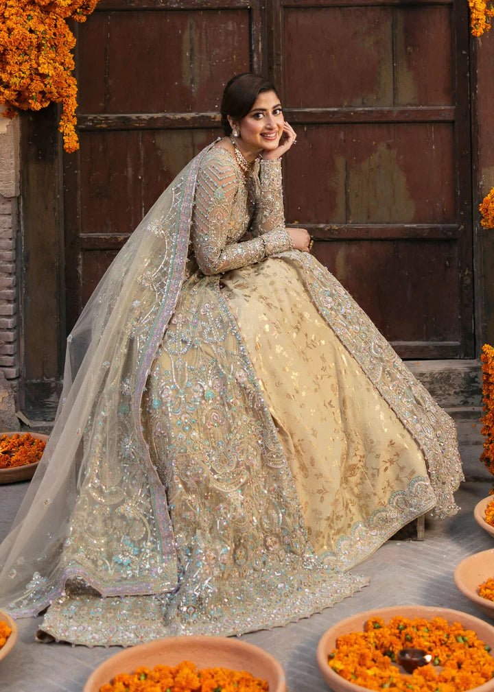 Model wearing Kanwal Malik Maahi Wedding Festive '24 ZOFIA, a luxurious champagne - colored bridal dress adorned with intricate embellishments, perfect for weddings. Available for Pakistani clothes online in the UK.