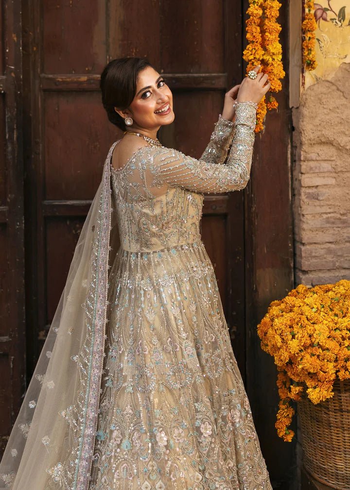 Model wearing Kanwal Malik Maahi Wedding Festive '24 ZOFIA, a luxurious champagne - colored bridal dress adorned with intricate embellishments, perfect for weddings. Available for Pakistani clothes online in the UK.