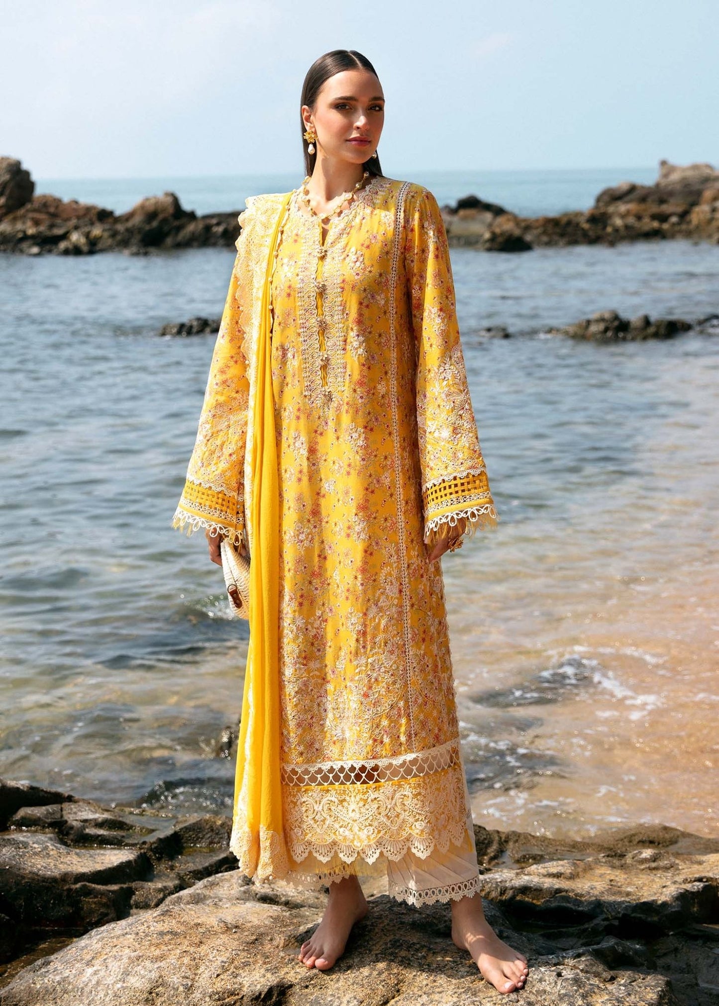 Model wearing Kanwal Malik Elara dress in vibrant yellow, showcasing detailed embroidery, ideal for Eid clothes in the UK and Pakistani lawn dresses.