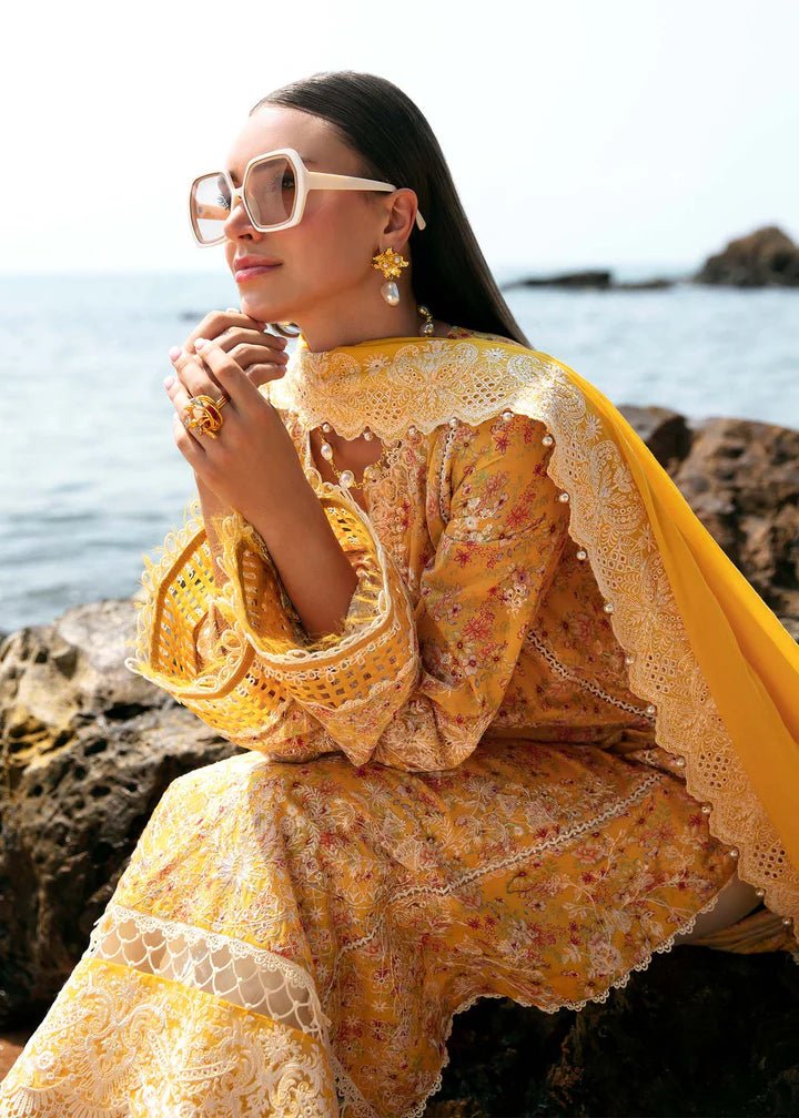 Model wearing a yellow Elara dress from Kanwal Malik's Mayal Luxury Lawn collection, featuring delicate lace detailing and floral patterns. Perfect for Pakistani clothes online in the UK.