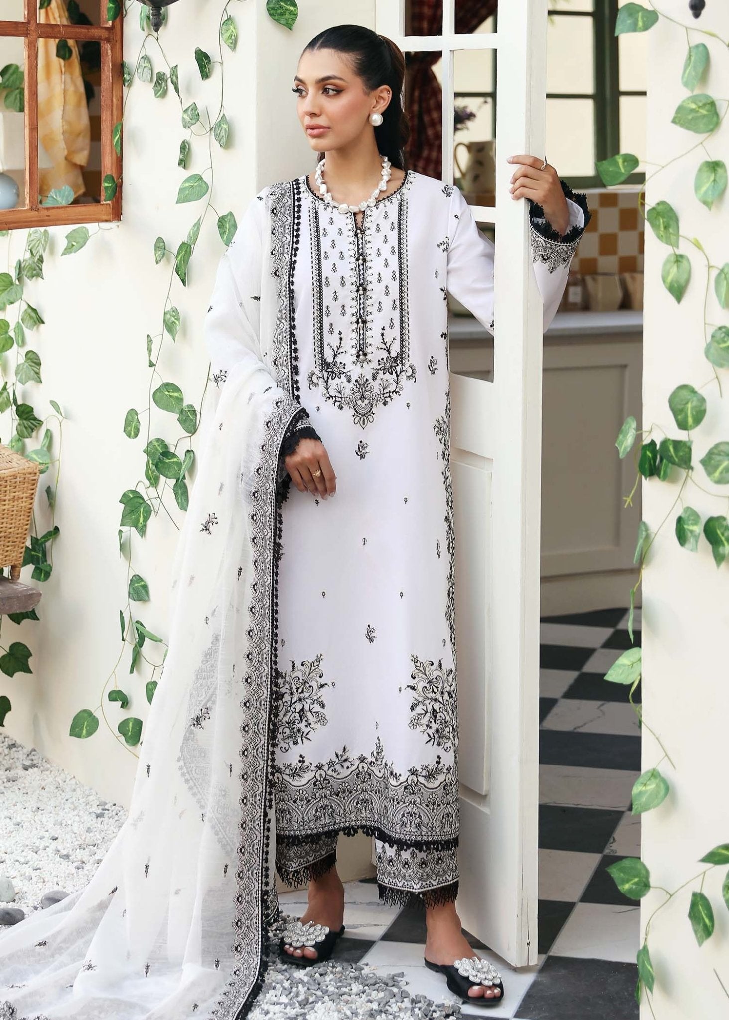 Model wearing Kanwal Malik Celine dress in black and white, perfect for Pakistani designer clothes in UK, readymade lawn suits, showcasing elegance and intricate details.