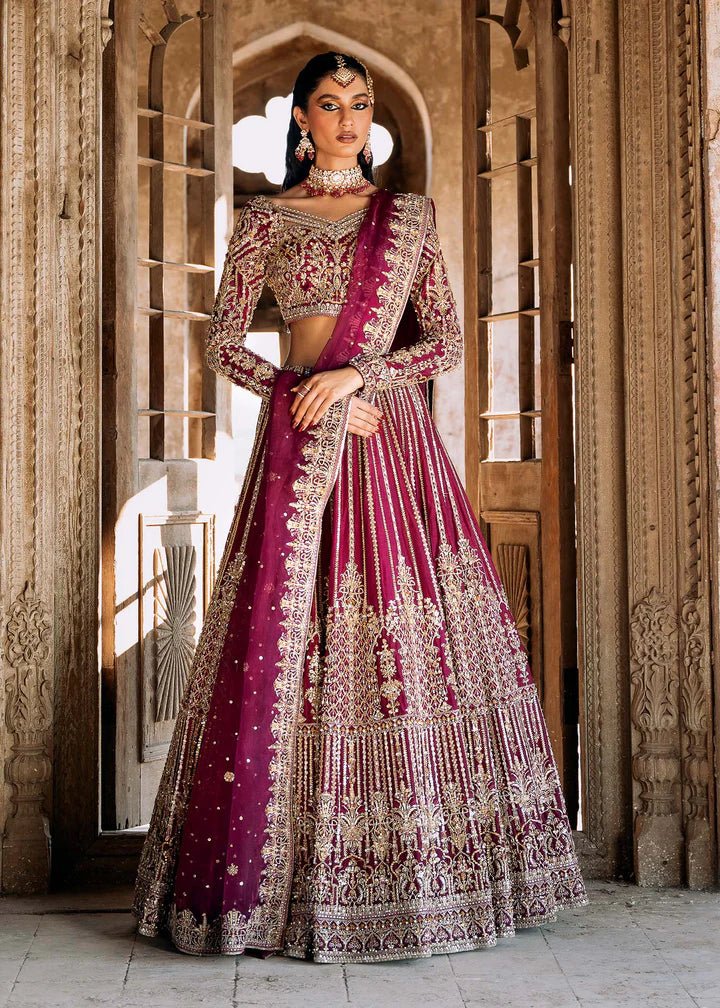 Model wearing a deep magenta and gold embellished Raina lehenga from Kanwal Malik's Sajni II collection. Pakistani wedding clothes online in the UK.