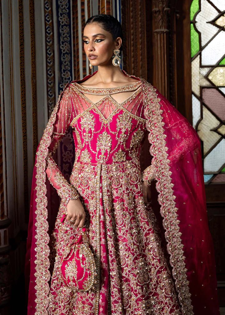 Model wearing a vibrant pink Sarosh dress from Kanwal Malik's Sajni II Formal Collection, adorned with intricate gold embroidery, paired with a matching dupatta. Pakistani wedding clothes available online in the UK.