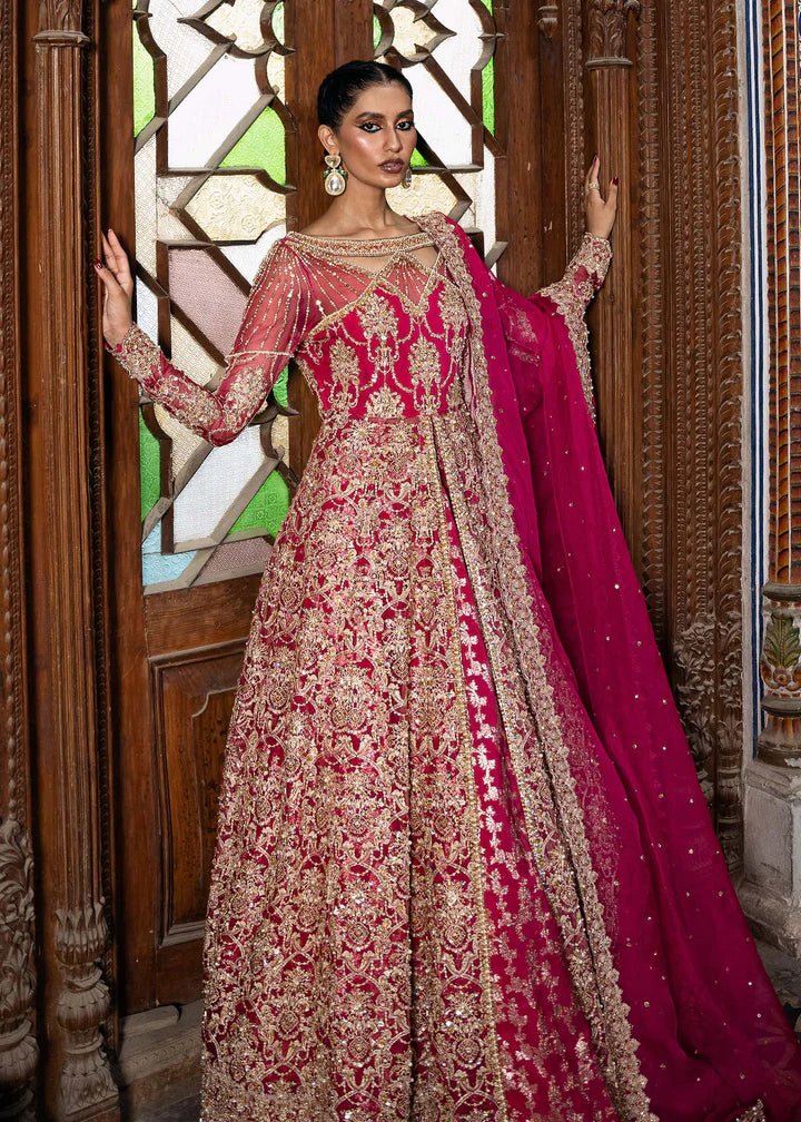 Model wearing a vibrant pink Sarosh dress from Kanwal Malik's Sajni II Formal Collection, adorned with intricate gold embroidery, paired with a matching dupatta. Pakistani wedding clothes available online in the UK.