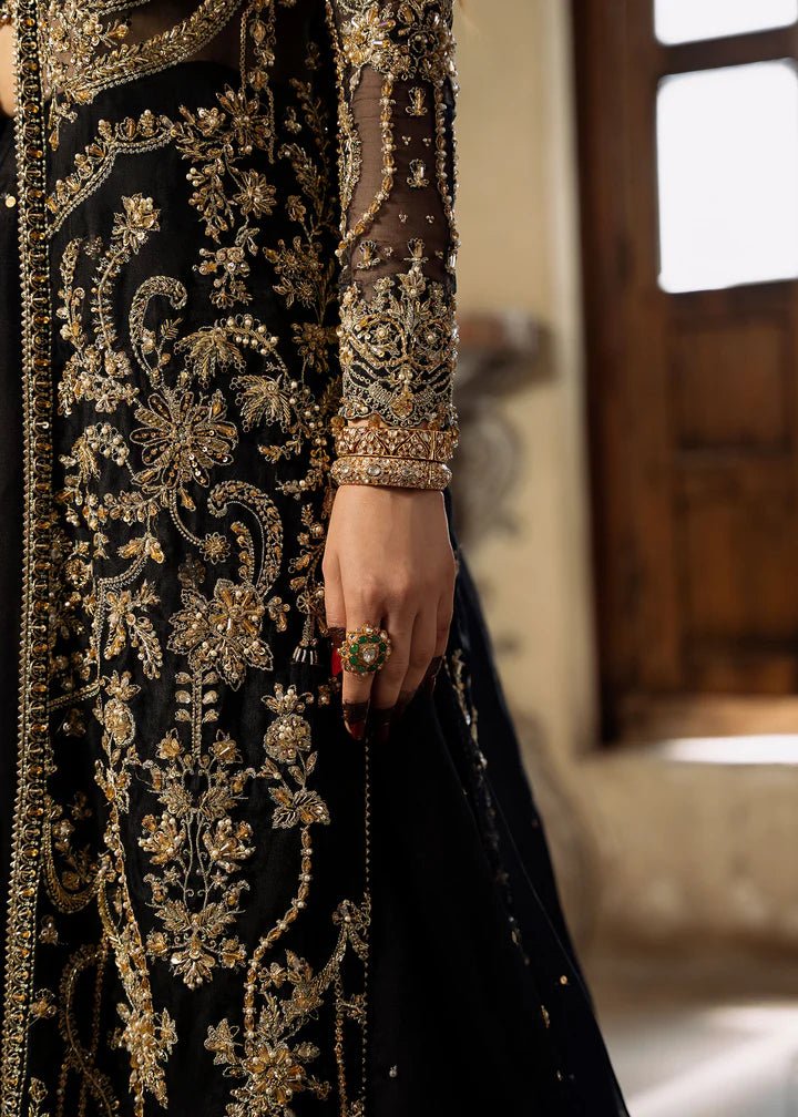 Model wearing a black and gold embellished Shahtaj formal dress from Kanwal Malik's Sajni II collection. Pakistani wedding clothes online in the UK.