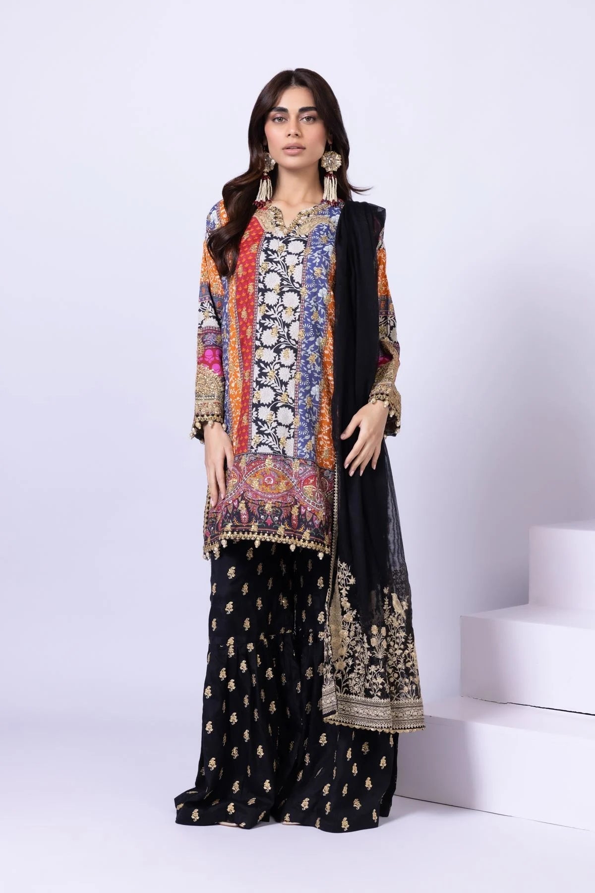 Model wearing Khaadi EST24558A multicolor dress with intricate prints and black embroidered gharara. Shop Pakistani clothes online in the UK now.