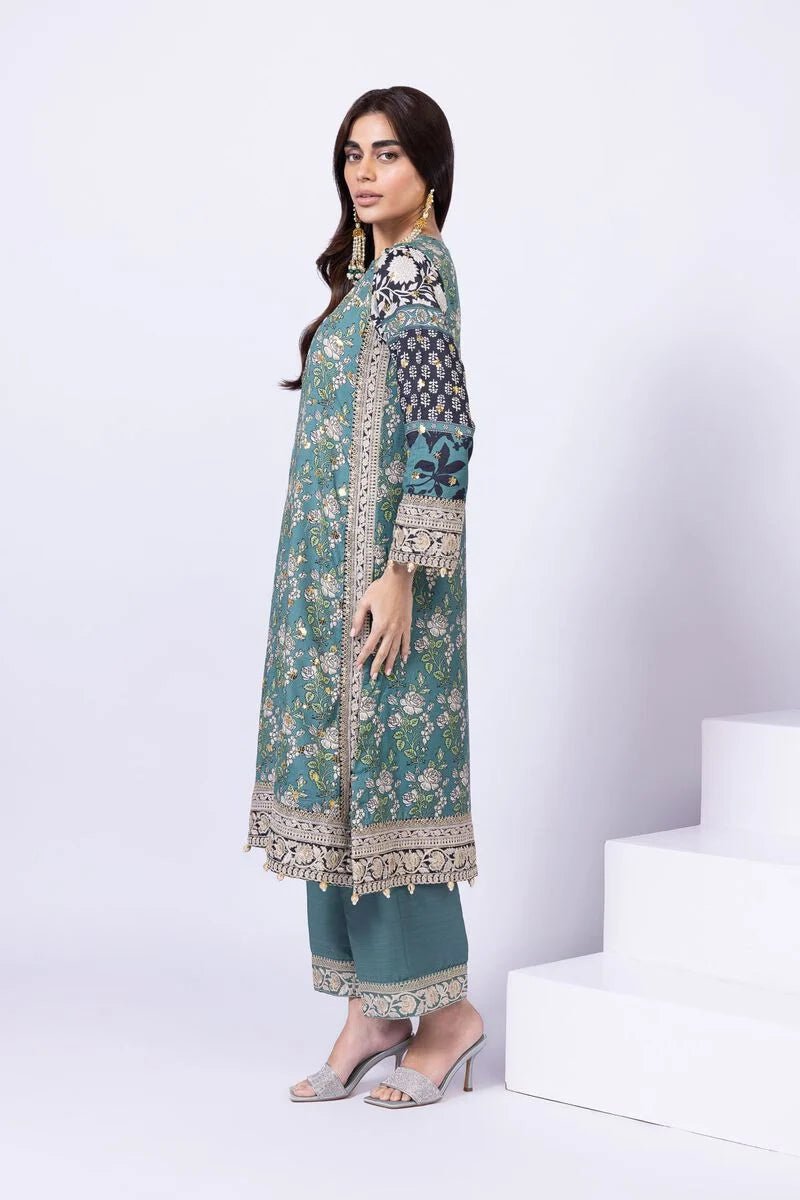 Model wearing Khaadi EST24563A teal dress with intricate prints and embroidered details. Shop Pakistani clothes online in the UK now.