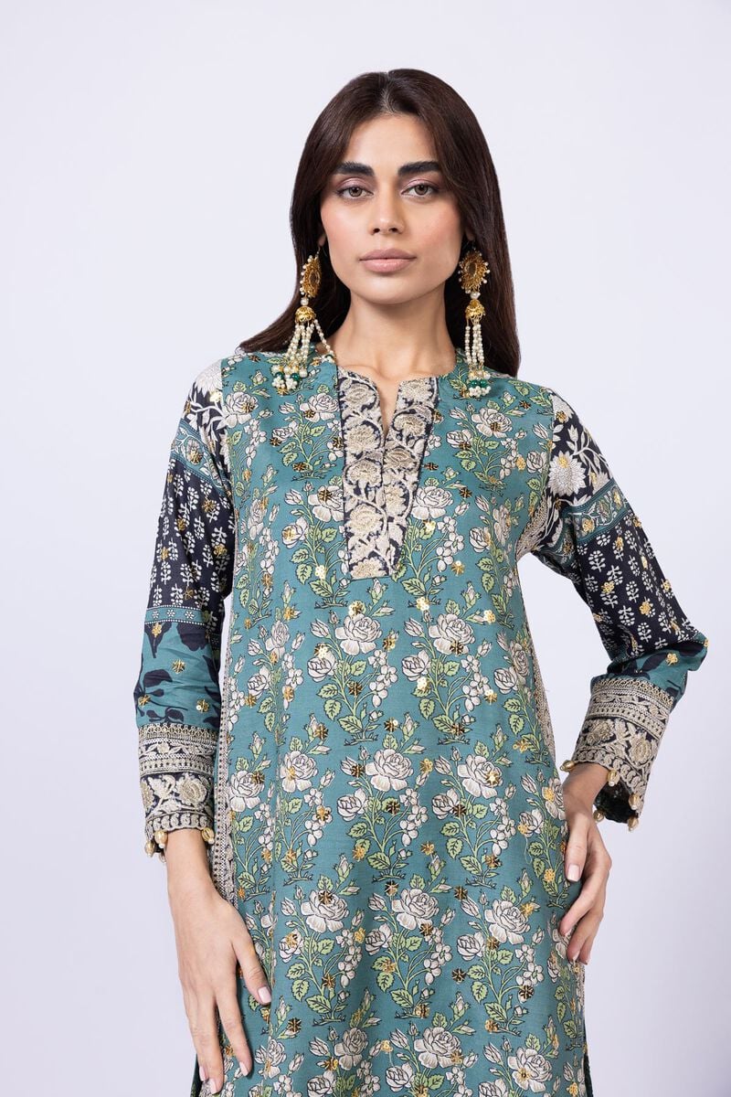 Model wearing Khaadi EST24563A teal dress with intricate prints and embroidered details. Shop Pakistani clothes online in the UK now.