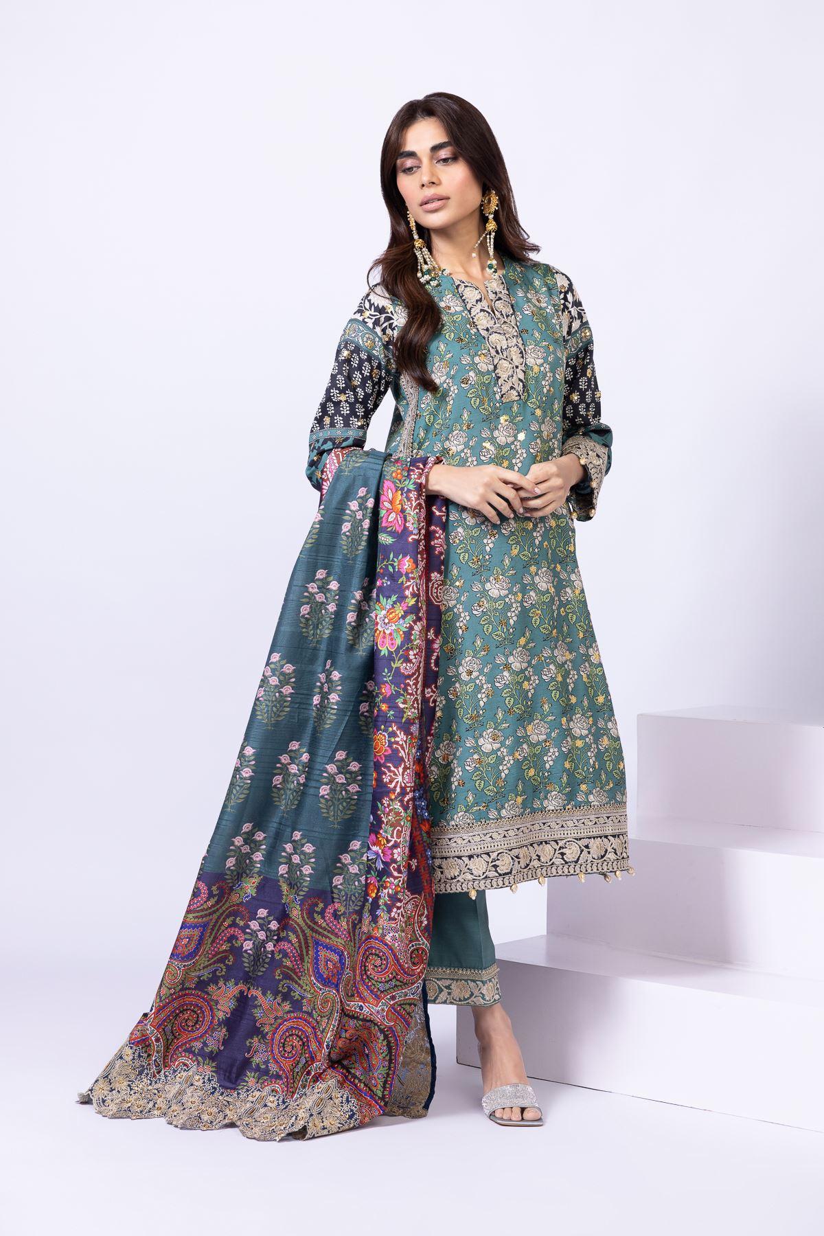 Model wearing Khaadi EST24563A teal dress with intricate prints and embroidered details. Shop Pakistani clothes online in the UK now.