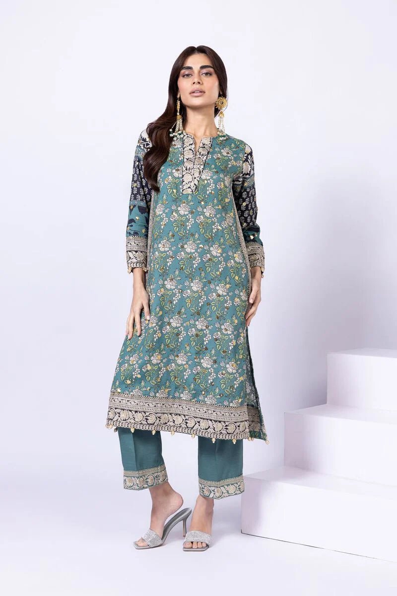 Model wearing Khaadi EST24563A teal dress with intricate prints and embroidered details. Shop Pakistani clothes online in the UK now.