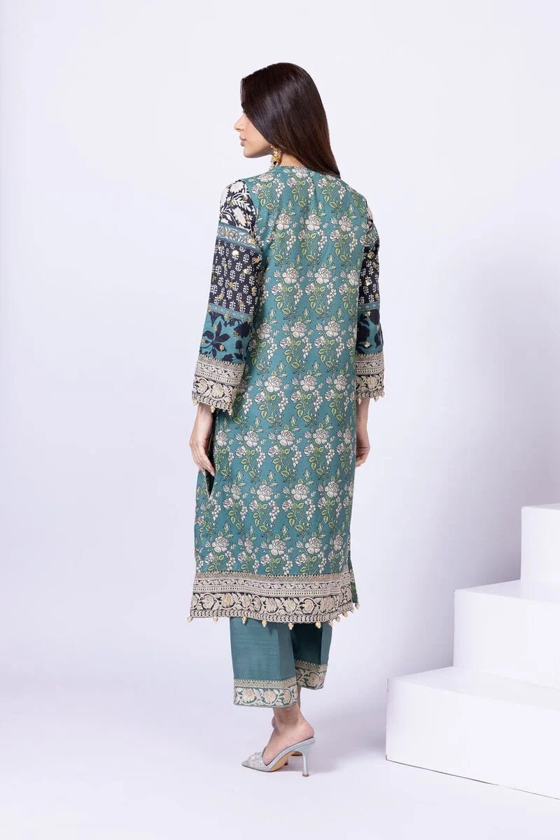 Model wearing Khaadi EST24563A teal dress with intricate prints and embroidered details. Shop Pakistani clothes online in the UK now.