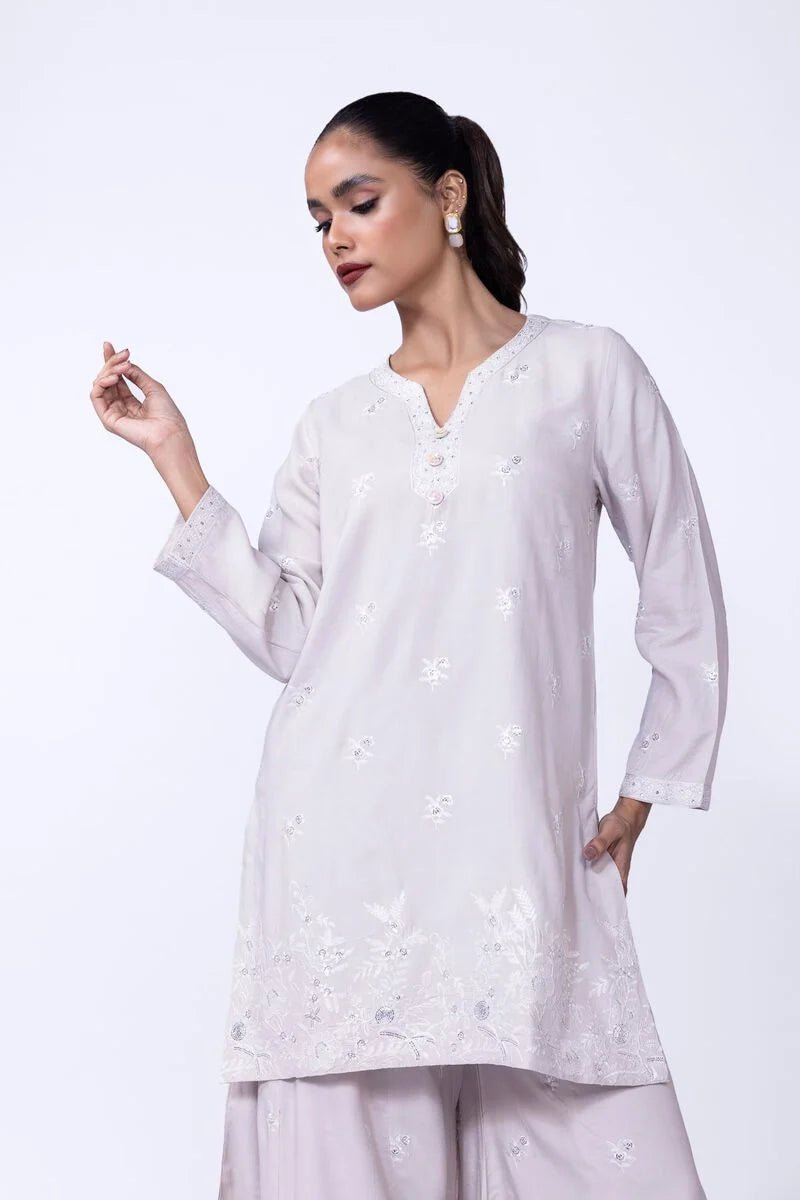 Model wearing Khaadi EST24601A beige dress with delicate white embroidery and elegant design. Shop Pakistani clothes online in the UK now.