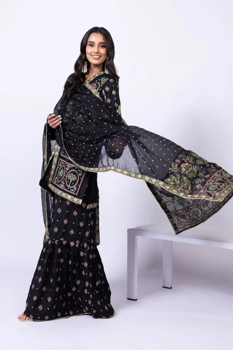 Model wearing Khaadi EST24608A black dress with intricate multicolor embroidery and gharara. Shop Pakistani clothes online in the UK now.