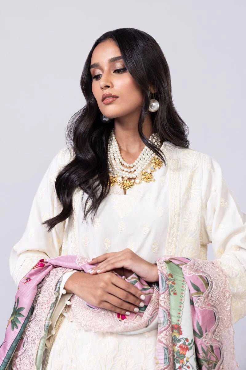 Model wearing Khaadi EST24609A off - white dress with delicate embroidery and a vibrant pink and green printed dupatta. Shop Pakistani clothes online in the UK now.