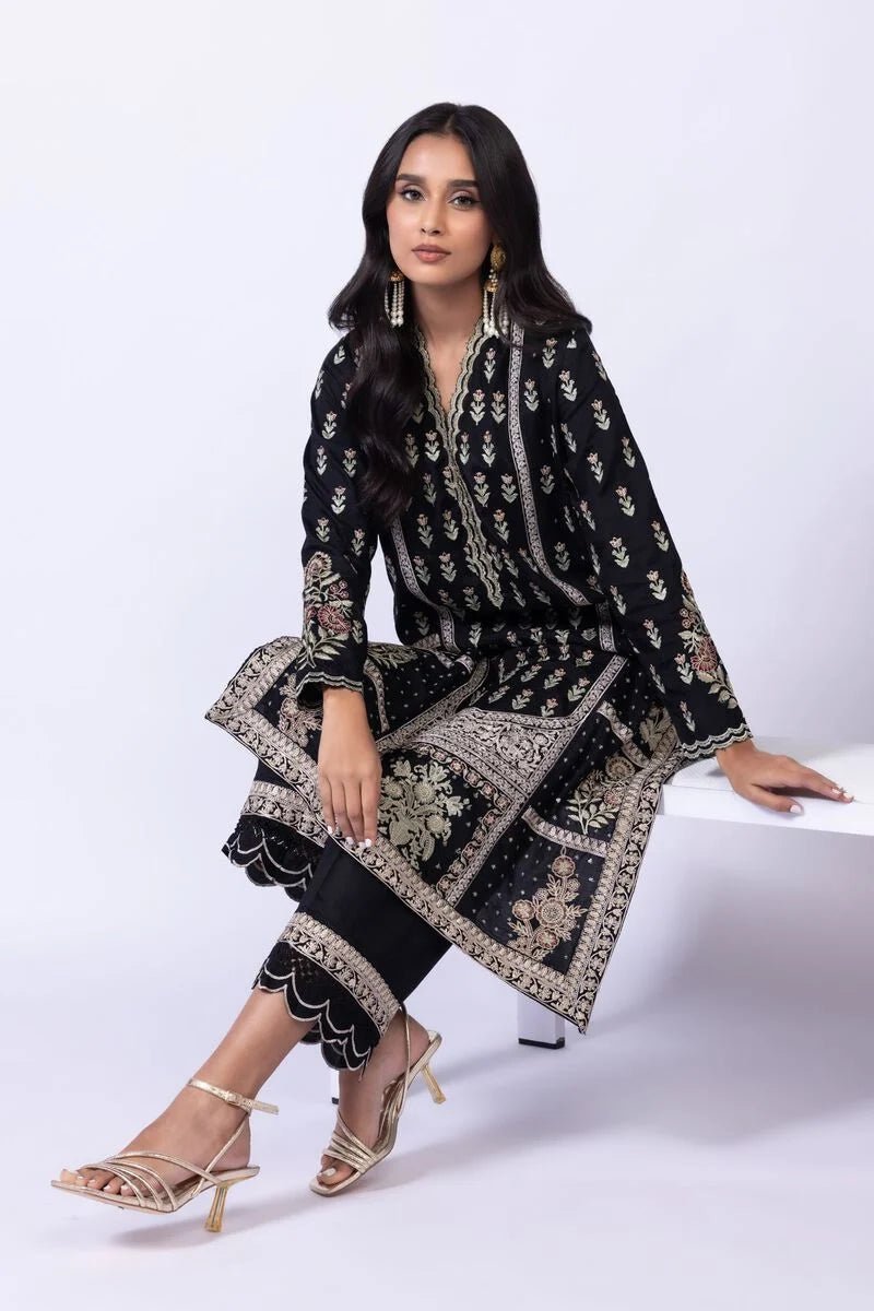 Model wearing Khaadi EST24610B black dress with intricate red and gold prints. Shop Pakistani clothes online in the UK now.