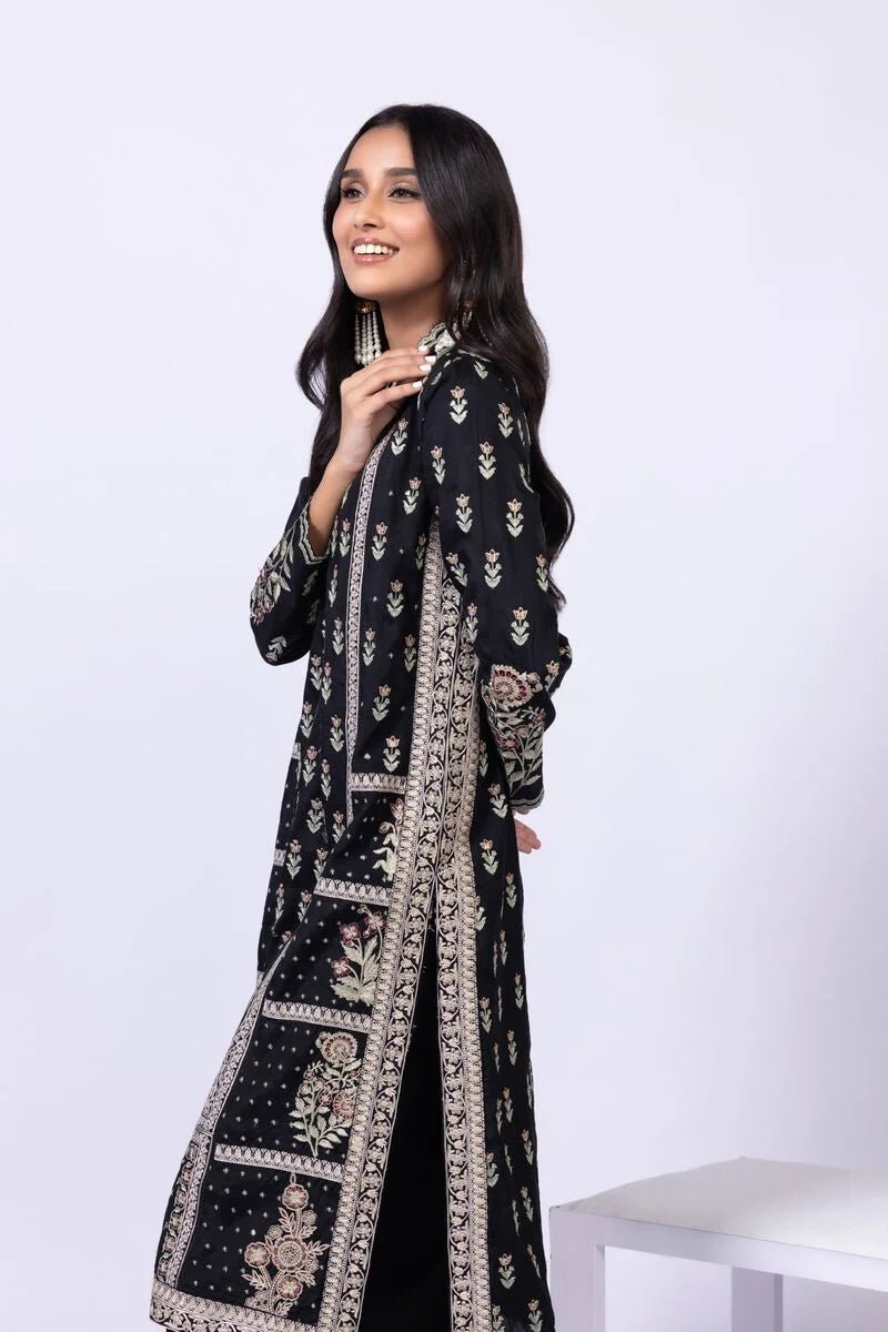 Model wearing Khaadi EST24610B black dress with intricate red and gold prints. Shop Pakistani clothes online in the UK now.