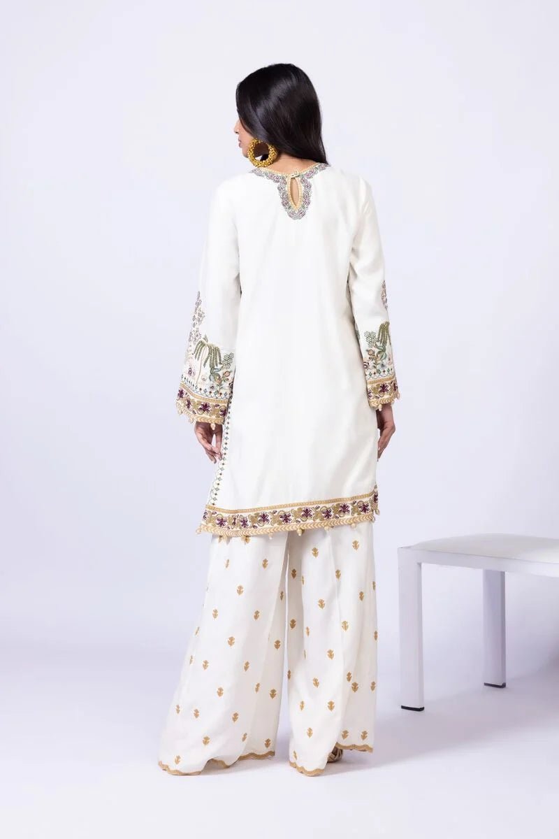 Model wearing Khaadi EST24613B off - white dress with intricate multicolor embroidery. Shop Pakistani clothes online in the UK now.