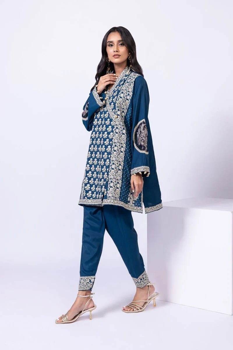 Model wearing Khaadi EST24615A teal dress with intricate embroidery and tassel details. Shop Pakistani clothes online in the UK now.