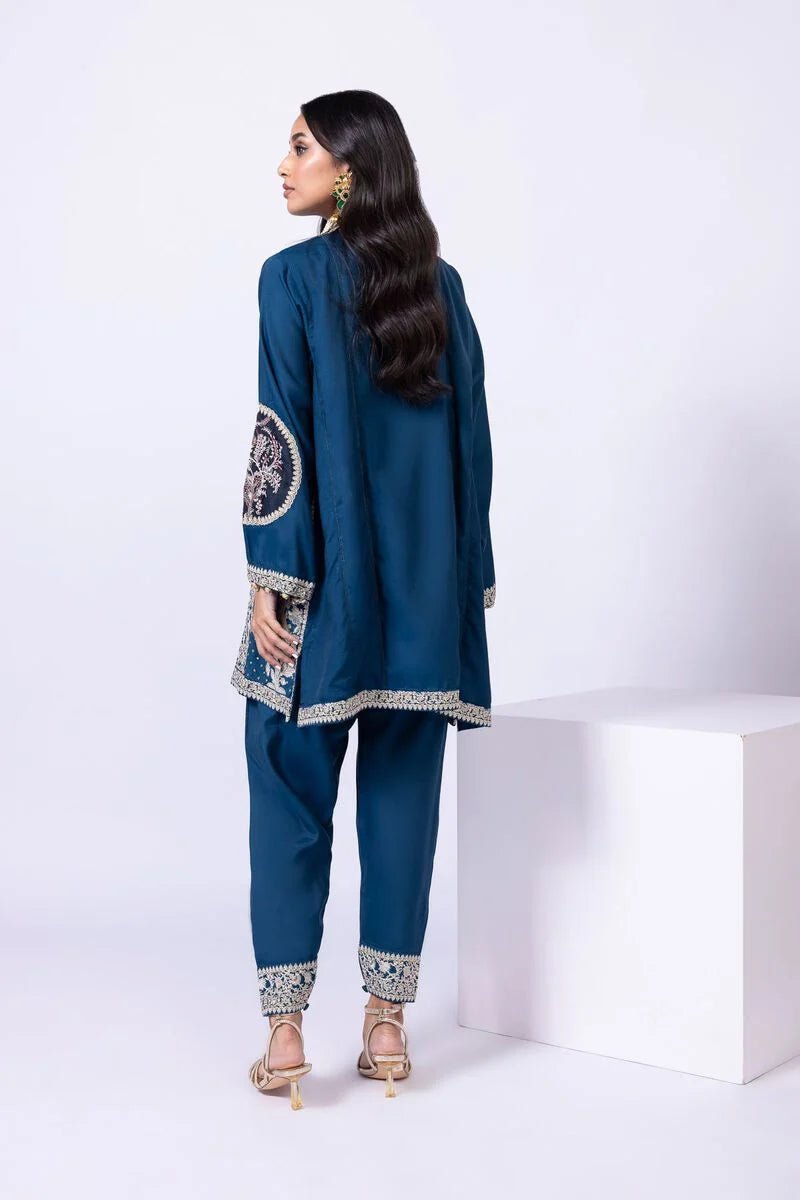 Model wearing Khaadi EST24615A teal dress with intricate embroidery and tassel details. Shop Pakistani clothes online in the UK now.