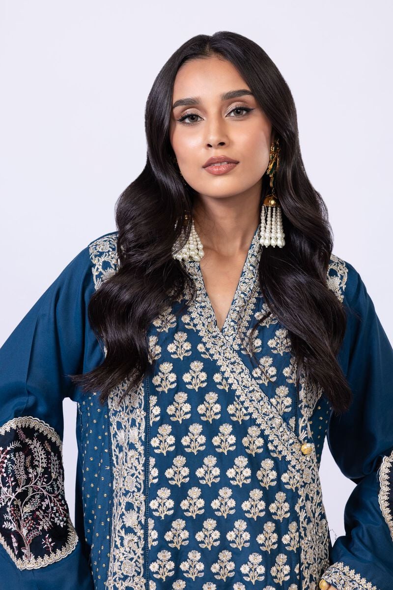 Model wearing Khaadi EST24615A teal dress with intricate embroidery and tassel details. Shop Pakistani clothes online in the UK now.