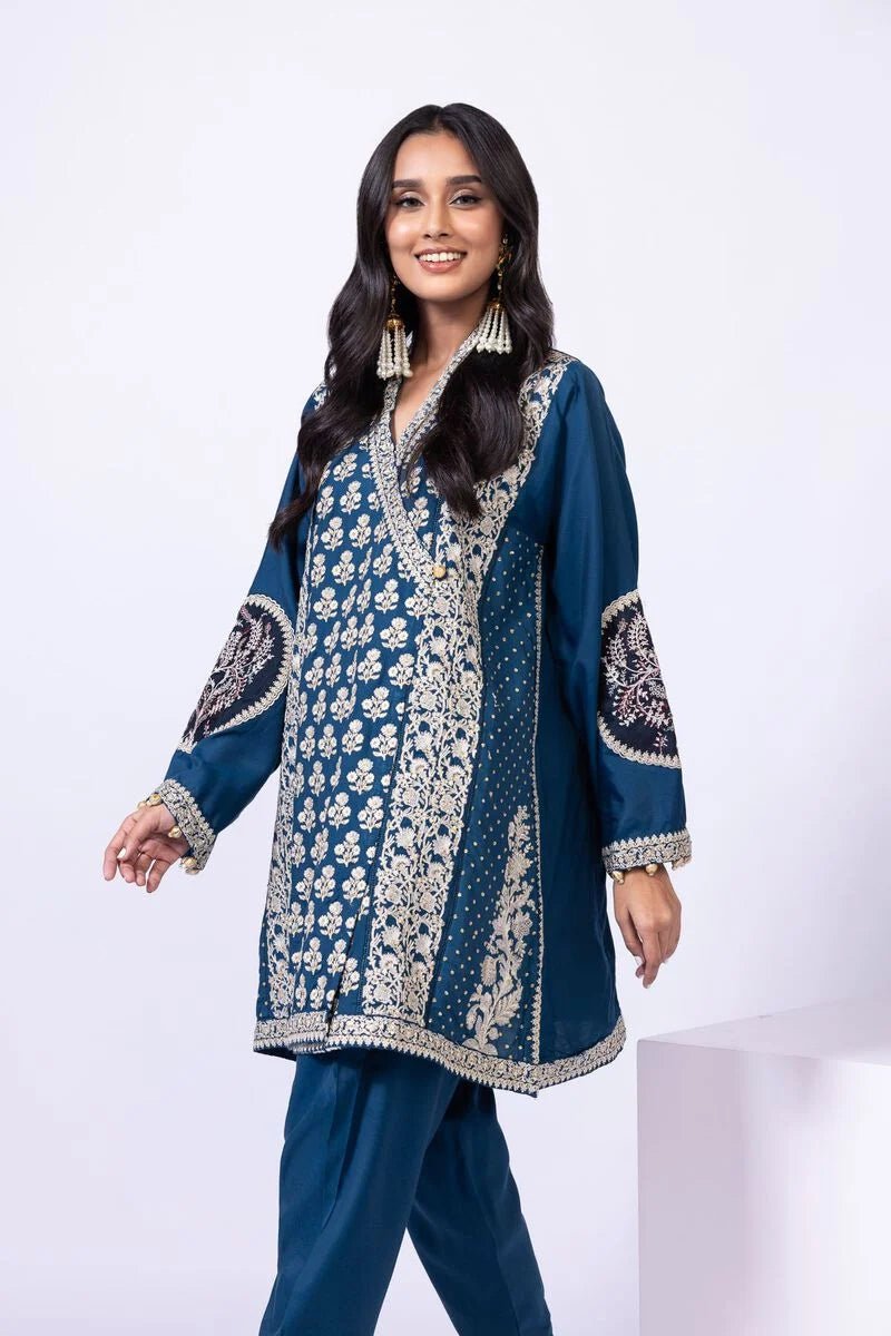 Model wearing Khaadi EST24615A teal dress with intricate embroidery and tassel details. Shop Pakistani clothes online in the UK now.