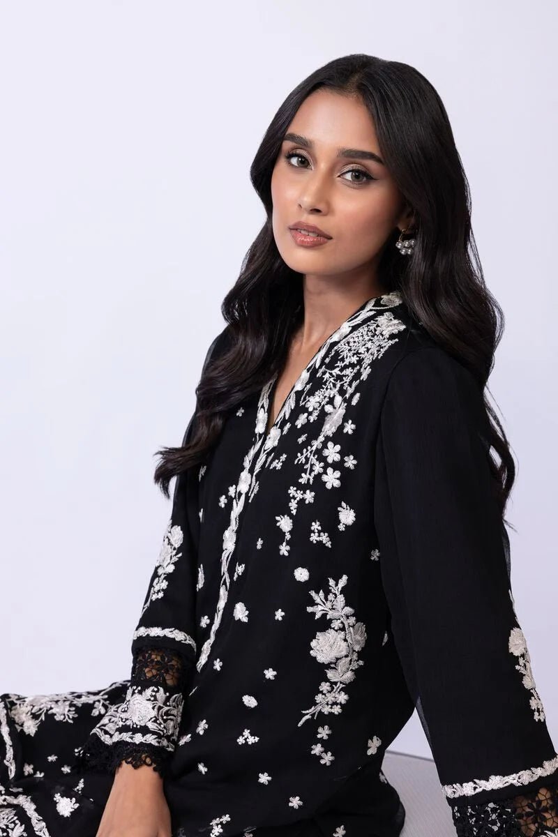 Model wearing Khaadi EST24633B black dress with elegant white embroidery and lace details. Shop Pakistani clothes online in the UK now.