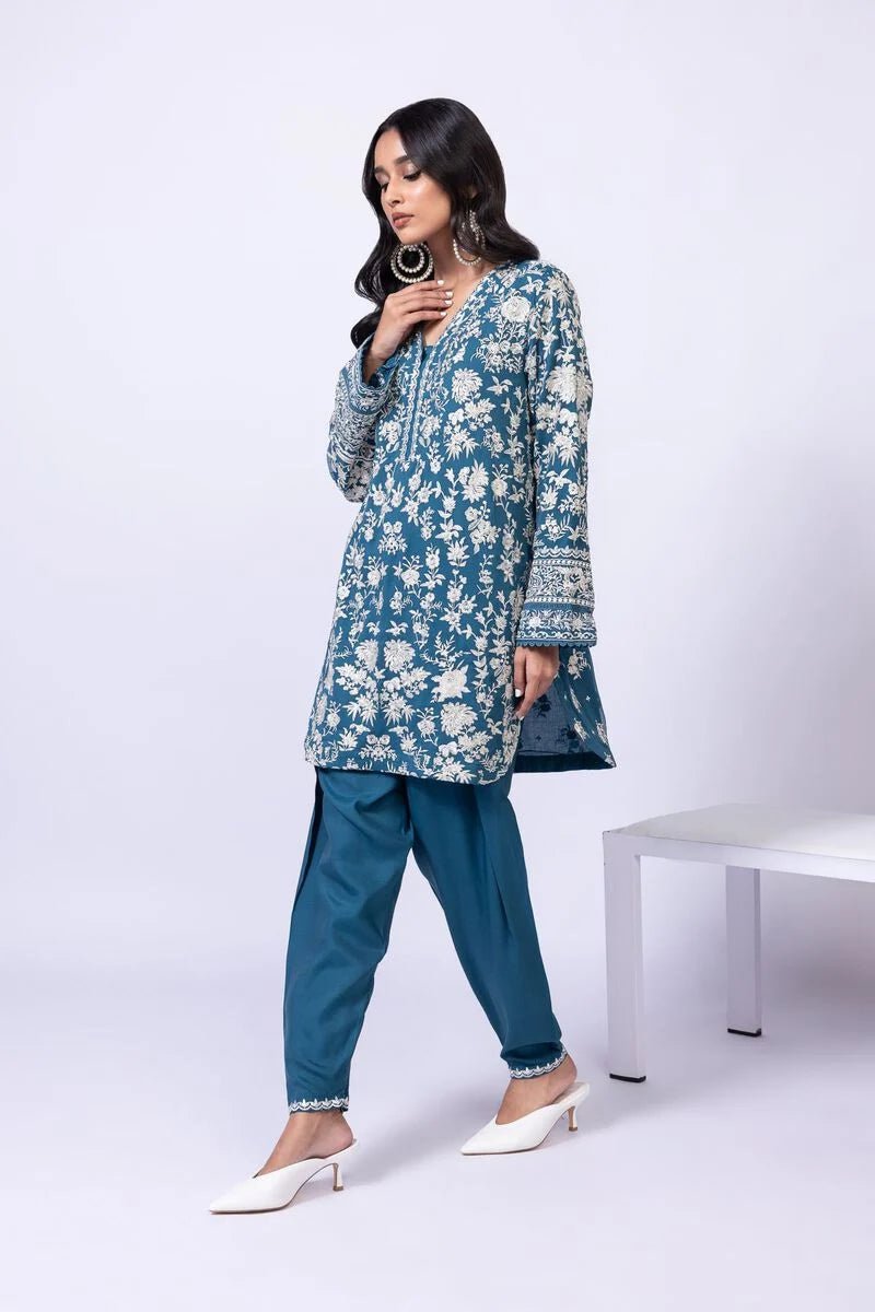 Model wearing Khaadi EST24634B teal blue embroidered dress with matching dupatta and trousers. Shop Pakistani clothes online in the UK now.