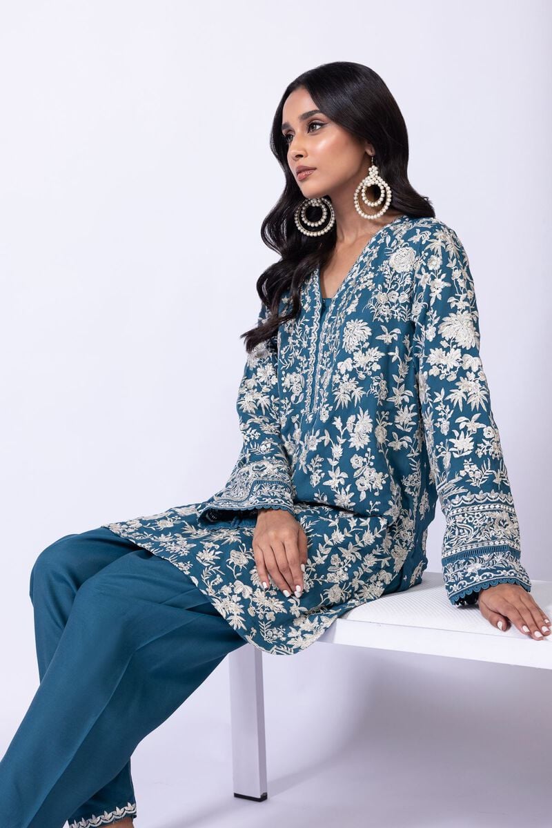 Model wearing Khaadi EST24634B teal blue embroidered dress with matching dupatta and trousers. Shop Pakistani clothes online in the UK now.