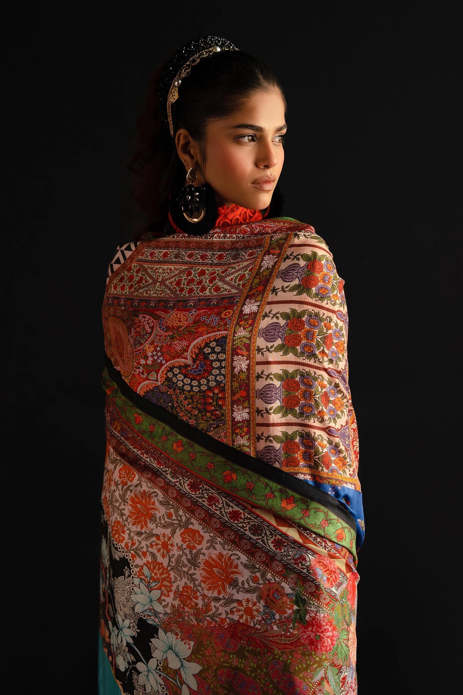 Model showcases Sana Safinaz's L241 - 001A - 3CL vibrant orange Pakistani dress, a UK luxury collection piece.