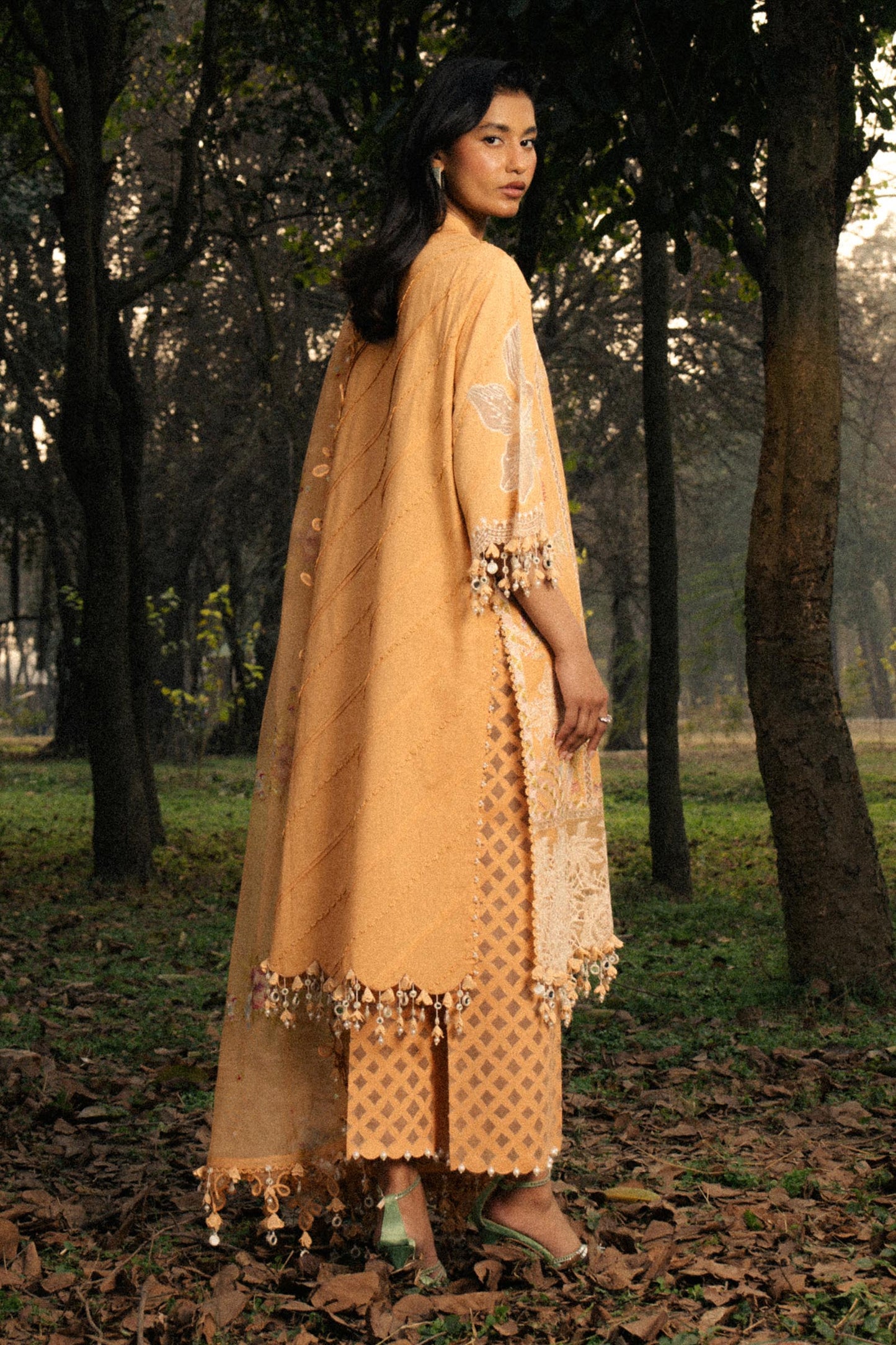 Model wearing mustard yellow embroidered dress with lace detailing from Sana Safinaz Luxury Lawn '25, Pakistani clothes online in UK.