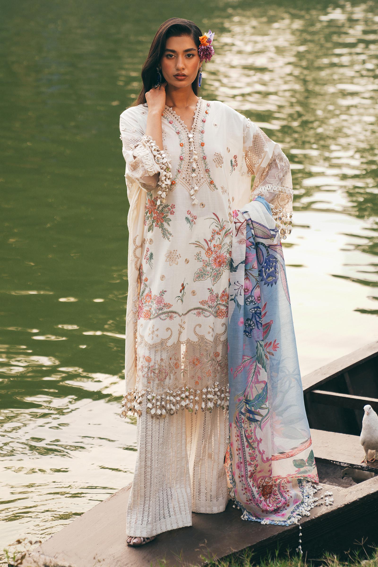 Model wearing ivory and pastel floral embroidered dress with printed dupatta from Sana Safinaz Luxury Lawn '25, Pakistani clothes online in UK.