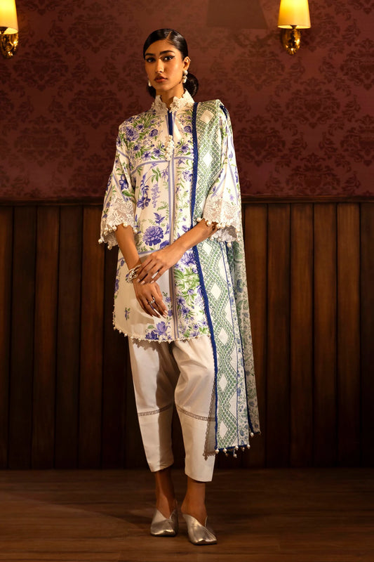 Model wearing a floral 3-piece suit from Sana Safinaz Muzlin Winter 2024 collection, featuring digital printed linen front, back, and sleeves with embroidered neckline and sleeves, paired with a khaddar dupatta and dyed cotton pants.