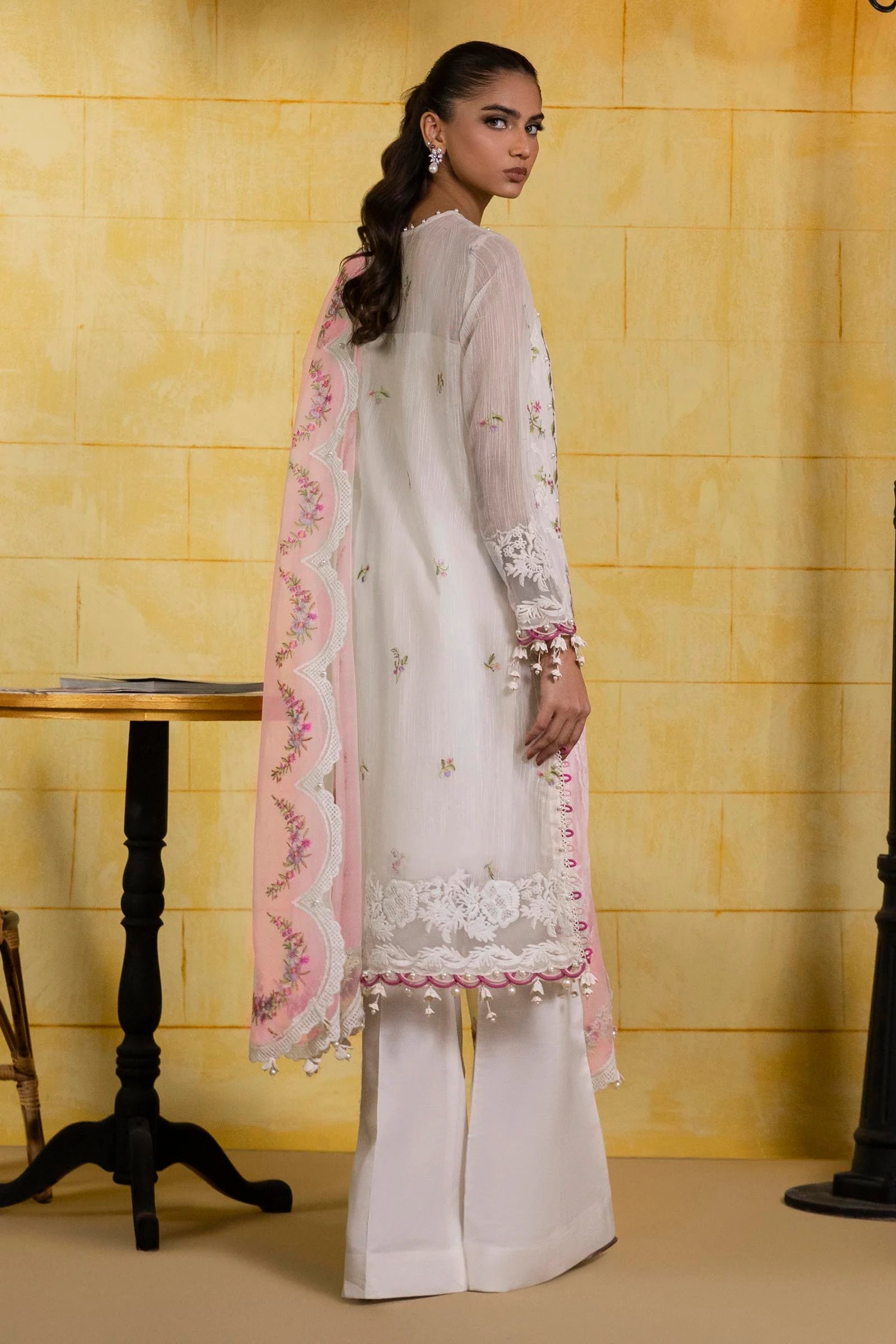 Model wearing ivory embroidered dress with pink scalloped dupatta from Sana Safinaz Muzlin Spring '25, Pakistani Luxury pret in UK.