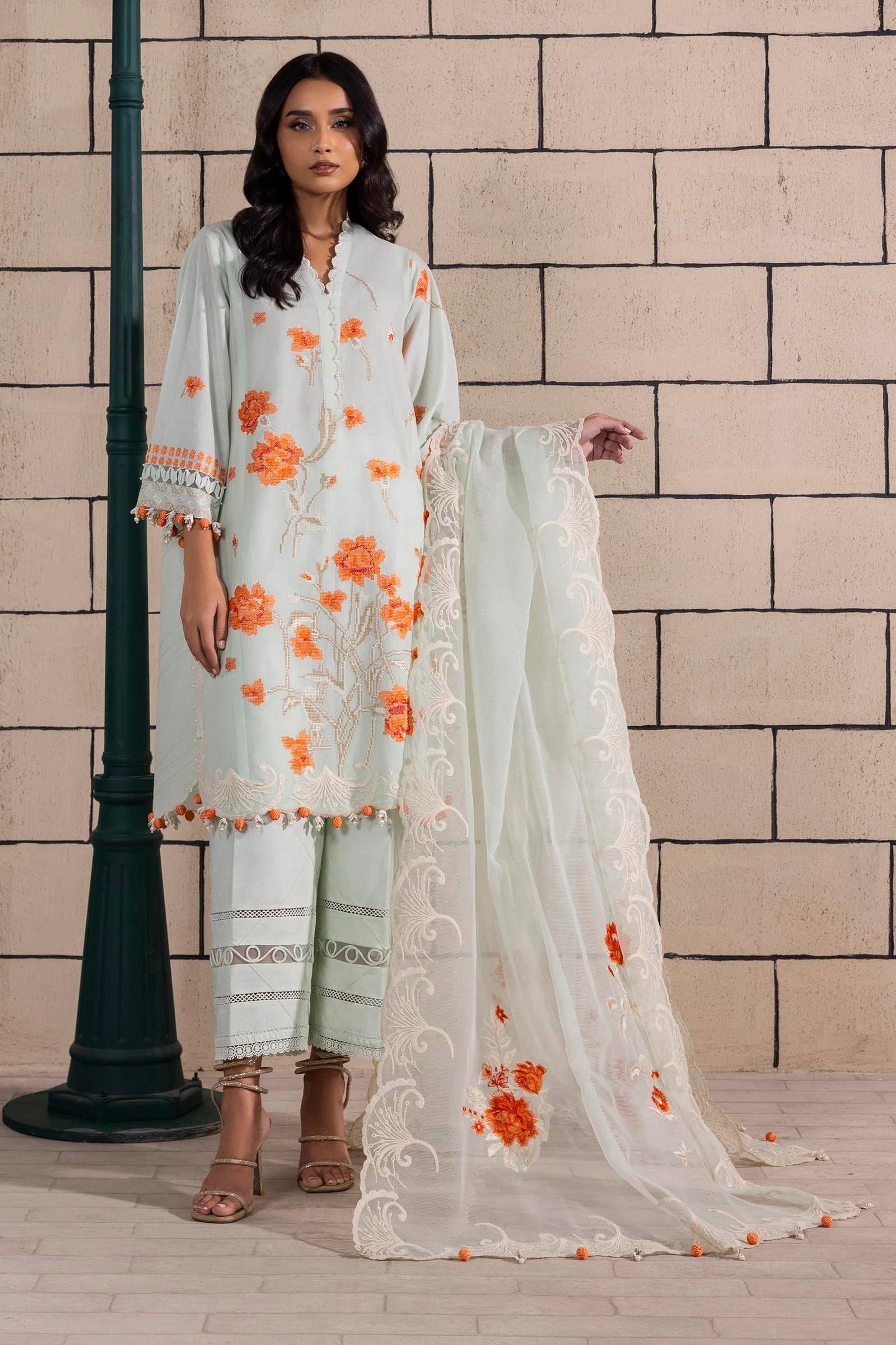 Model wearing mint green dress with orange floral embroidery and matching dupatta from Sana Safinaz Muzlin Spring '25, Pakistani Luxury pret UK.