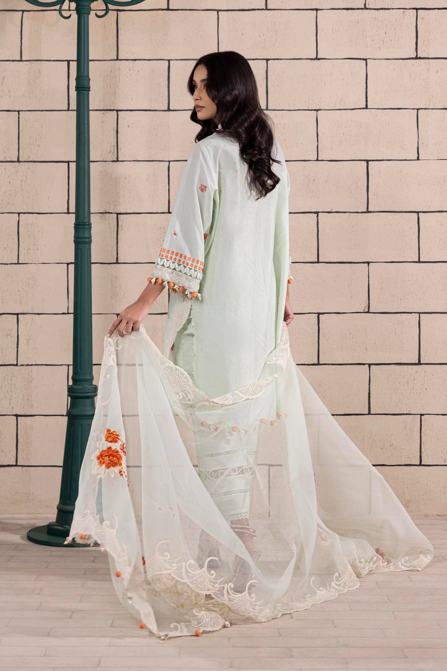 Model wearing mint green dress with orange floral embroidery and matching dupatta from Sana Safinaz Muzlin Spring '25, Pakistani Luxury pret UK.