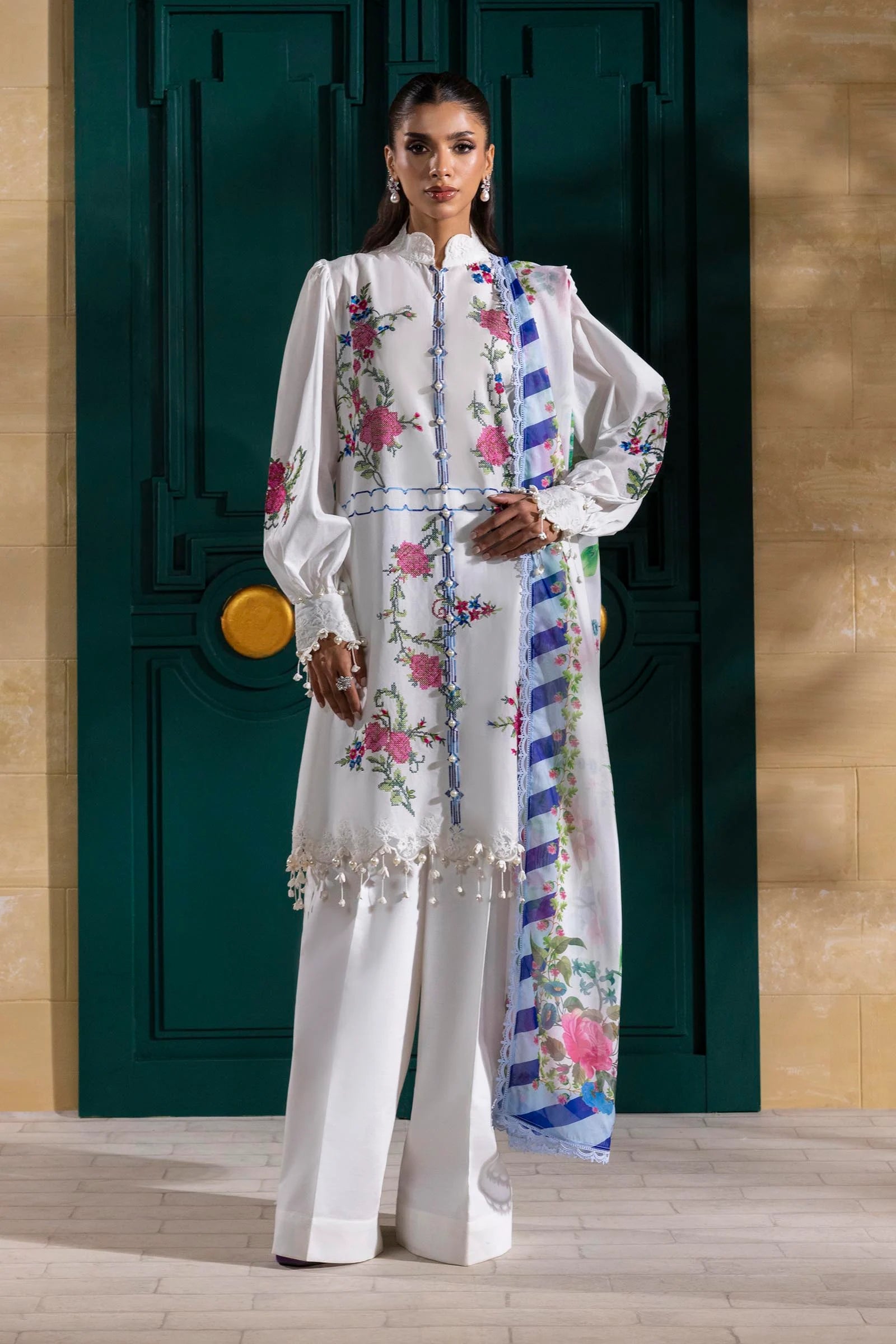 Model wearing white Sana Safinaz M251-013A-3CL outfit with vibrant pink floral embroidery and blue striped dupatta, Pakistani Luxury pret online UK.